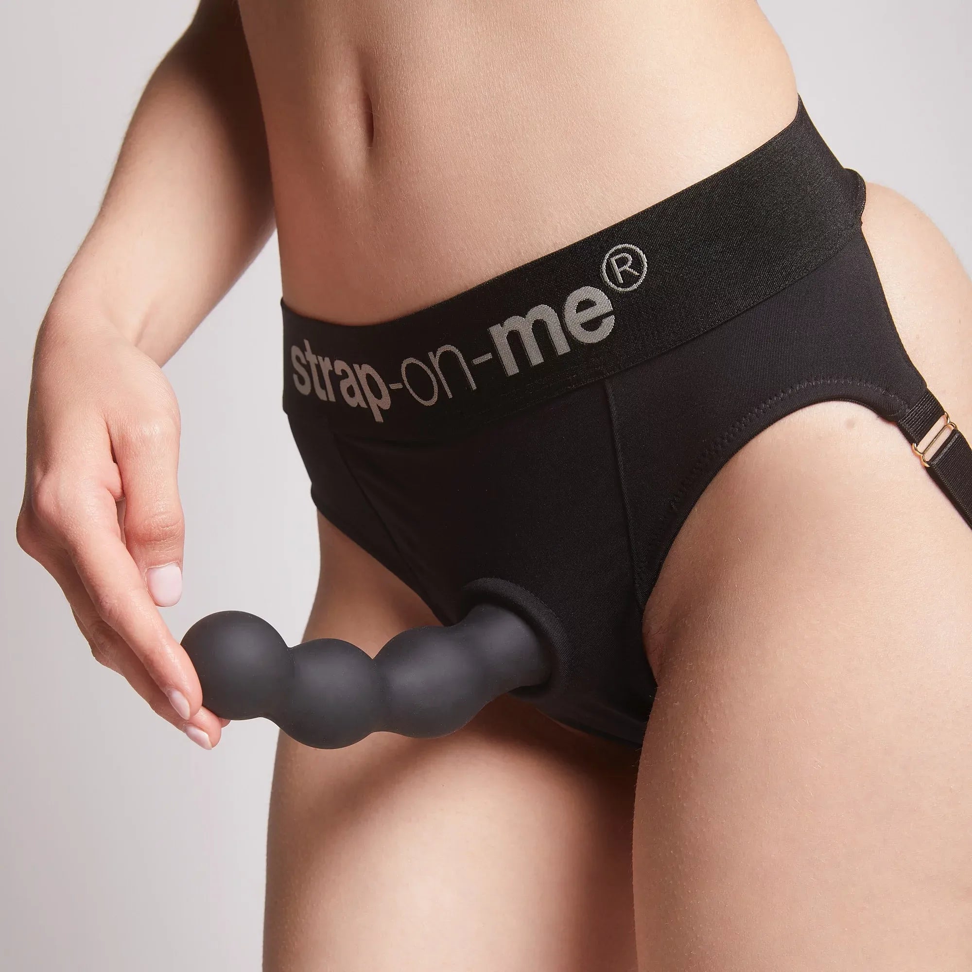 Stimulateur noir fixé grâce à sa ventouse pour une expérience mains libres