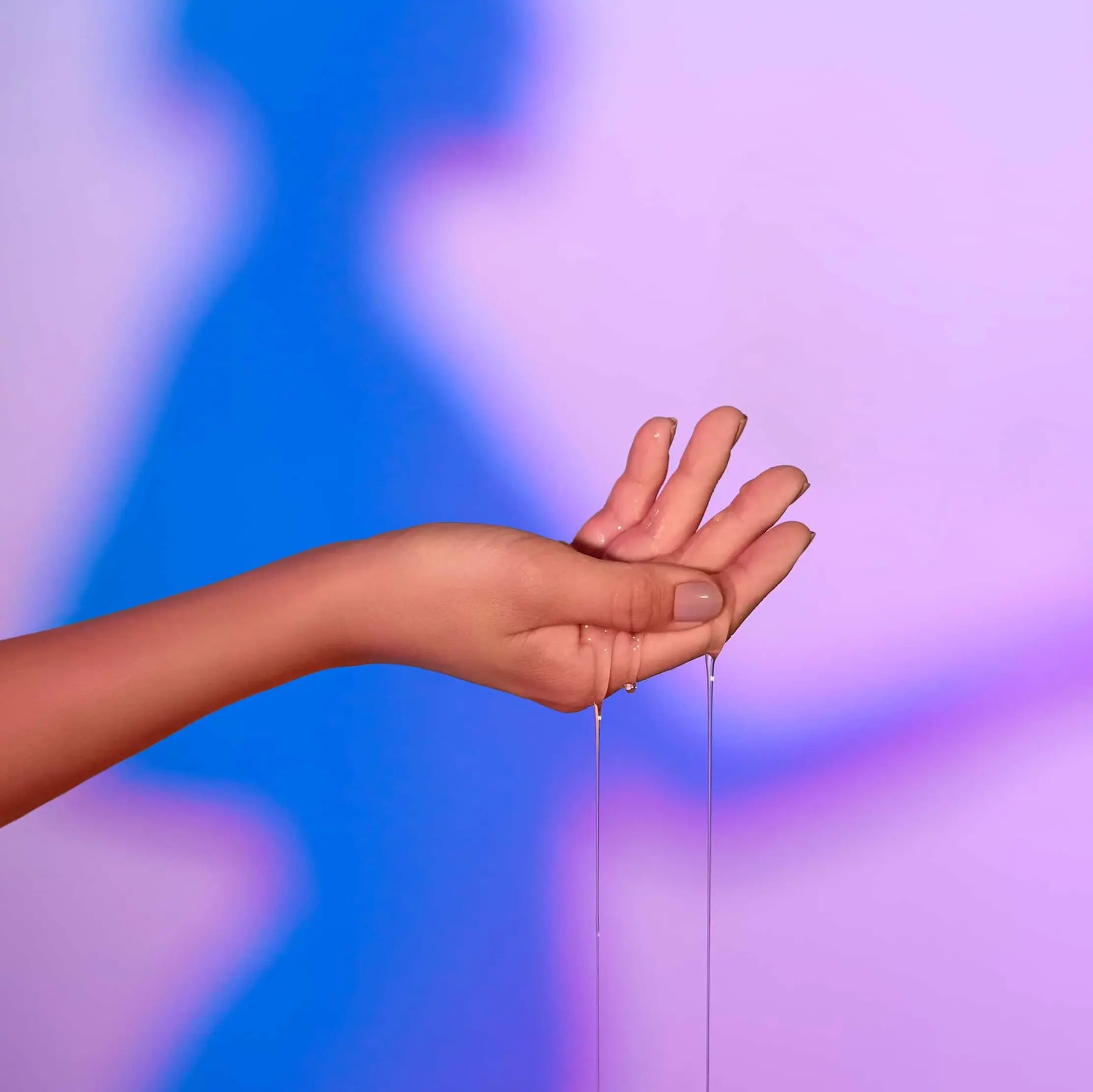 Huile de massage chauffante Love Me Tender coulant sur une main pour une application sensuelle