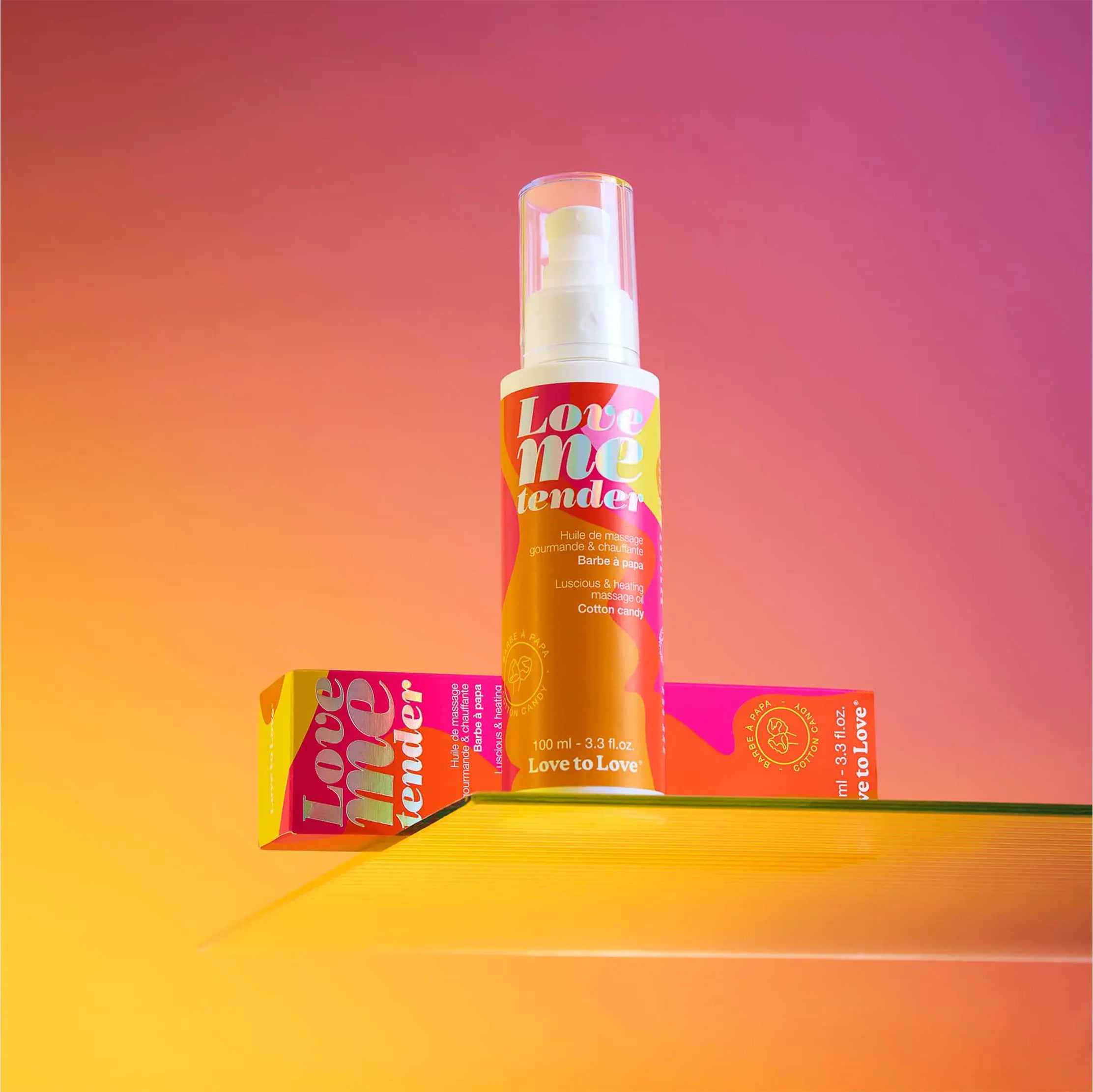 Mise en scène de l'huile de massage Love Me Tender sur fond coloré
