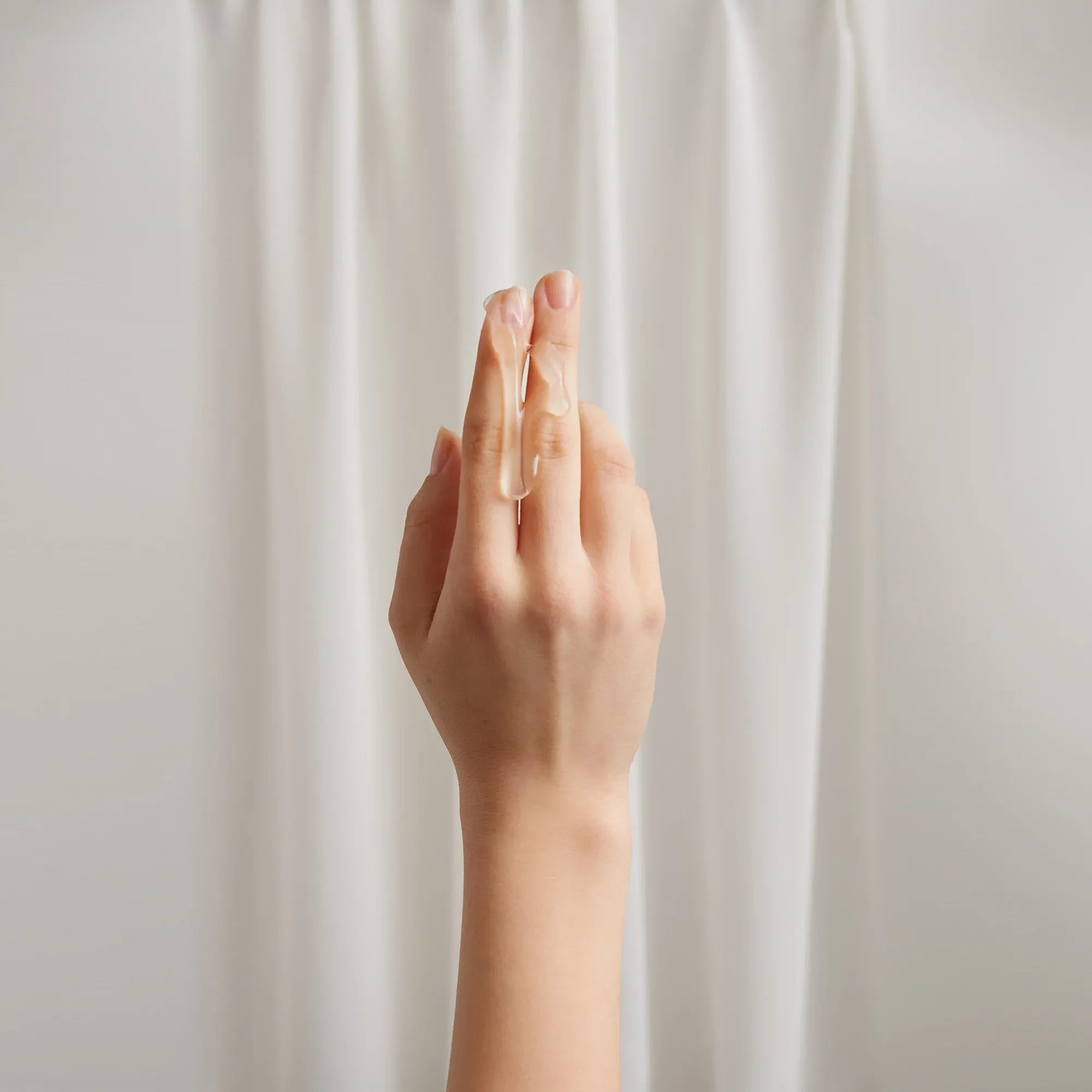 Geste évocateur de plaisir avec deux doigts – illustration suggérant l’utilisation d’un lubrifiant intime