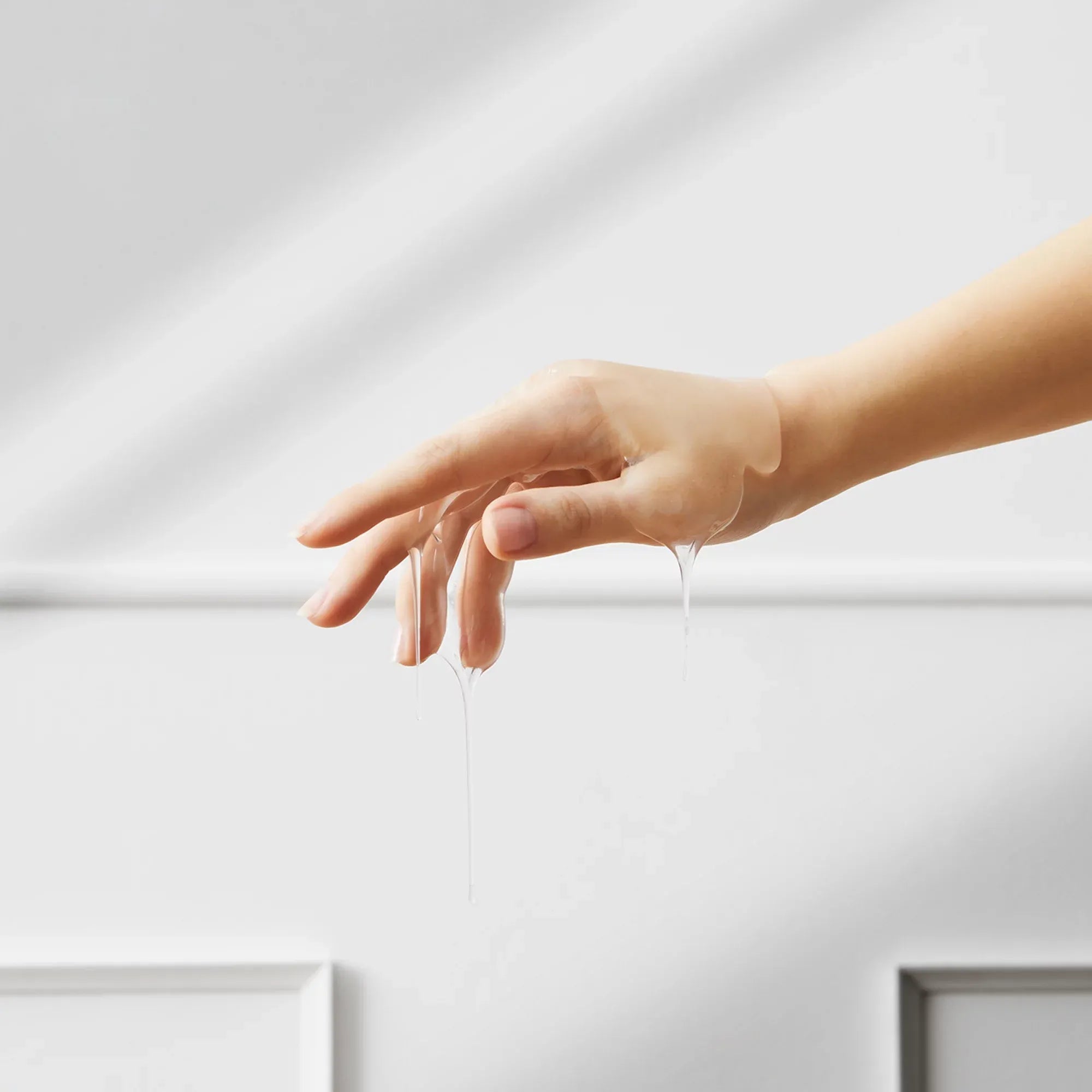 Geste délicat d’une main évoquant la sensualité – visuel suggérant l’usage d’un lubrifiant intime