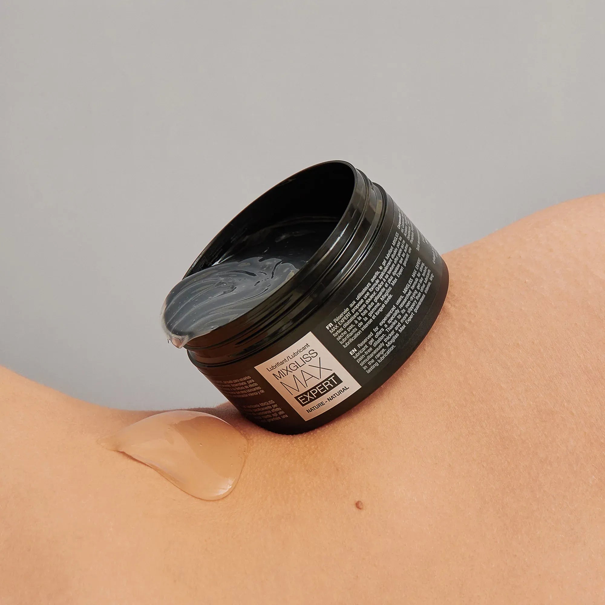 Gel lubrifiant Mixgliss Max Expert versé sur la peau – démonstration de texture épaisse et glissante