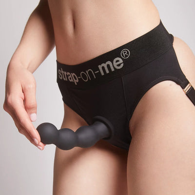 Stimulateur noir fixé grâce à sa ventouse pour une expérience mains libres