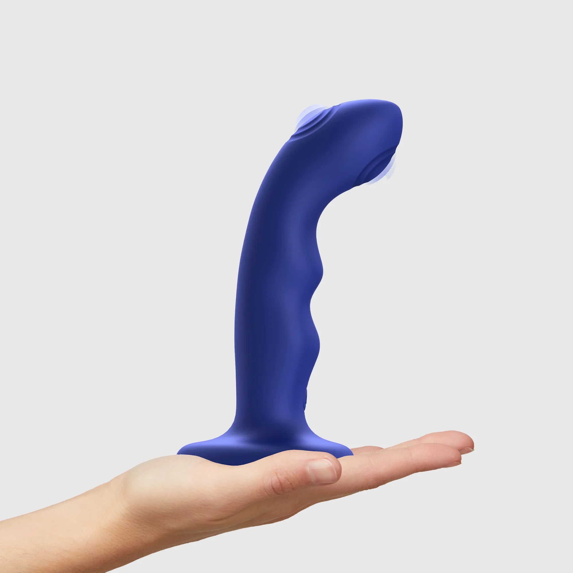 Dildo vibrant à double tapotement bleu tenu dans une main pour illustrer sa taille