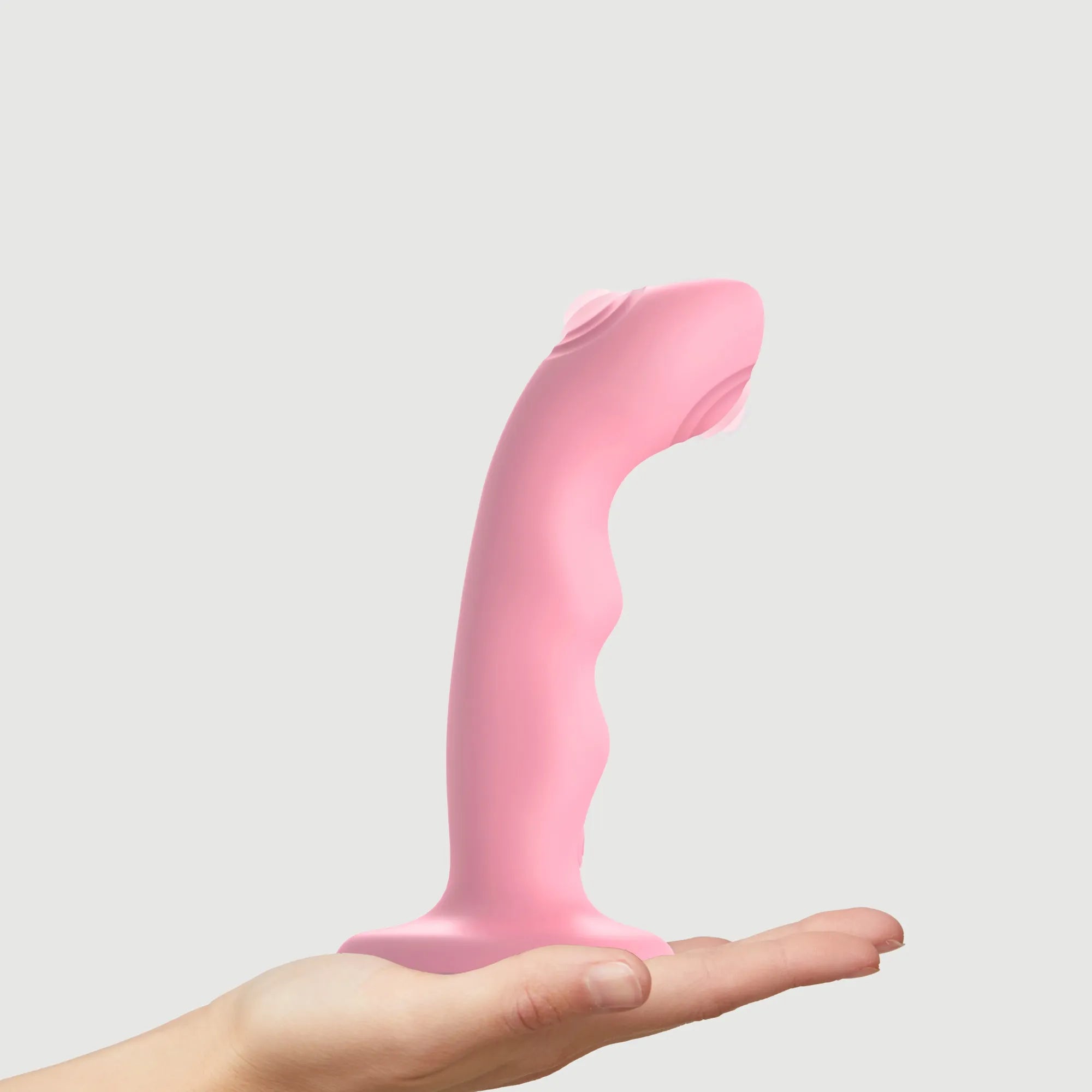 Dildo vibrant rose à double tapotement tenu dans une main pour illustrer sa taille