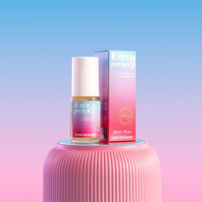 Flacon du gel relaxant anal EASY PEASY posé sur un support rose avec son packaging