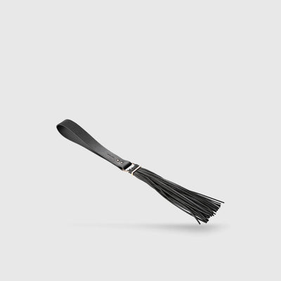 Fouet BDSM MAZE noir en simili, présenté seul pour mettre en avant son design élégant